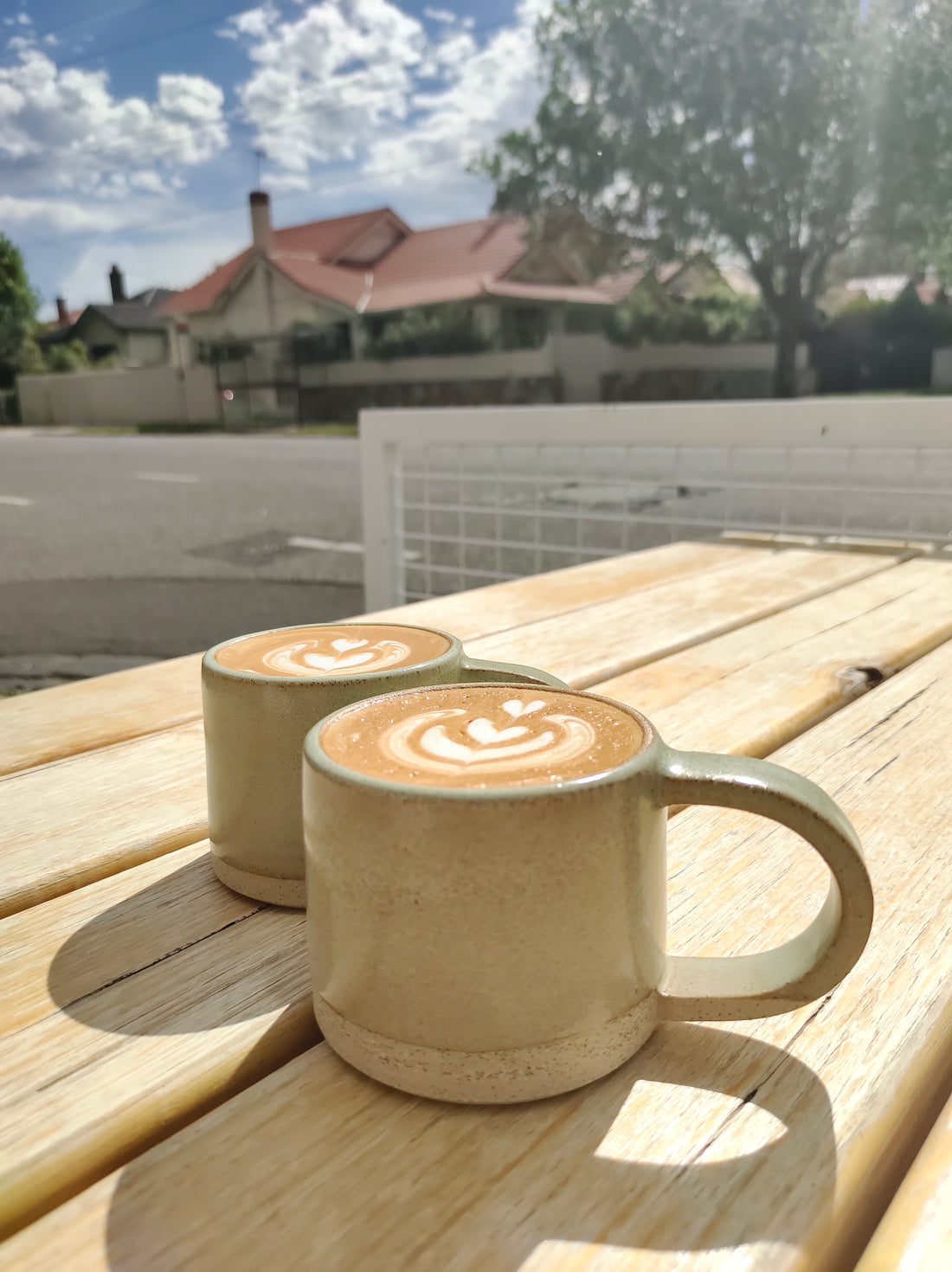 Handmade ceramic coffee mugs outside cafe