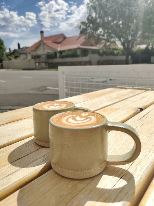 Handmade ceramic coffee mugs outside cafe
